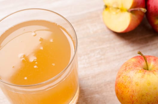 Organic apple juice with fresh apples on a wooden table