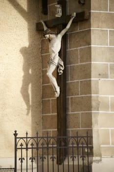 Baden,Austria - November 15,2015: A jesus figure on the cross casts a shadow on the wall of the parish church of St. Stephen on November 15,2015 in Baden near Vienna.