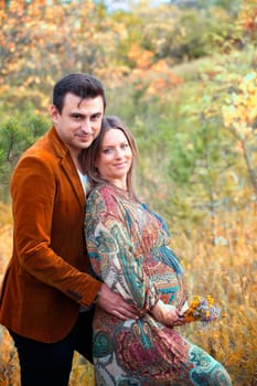 Pregnant woman with her husband relaxing outdoor.