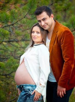 Pregnant woman with her husband relaxing outdoor.