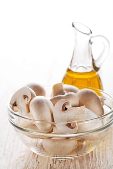 Mushrooms champignon and olive oil on white background.