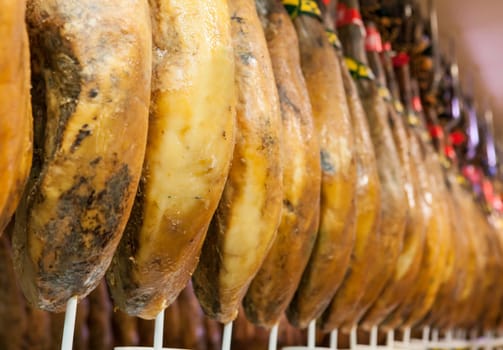 Line of cured iberico ham hanging legs. Spain