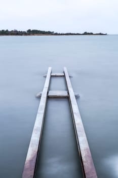 Steel Structure in Water with a cloudy sky.