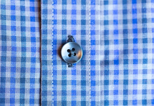 Shirt Button Close Up on blue and white shirt.