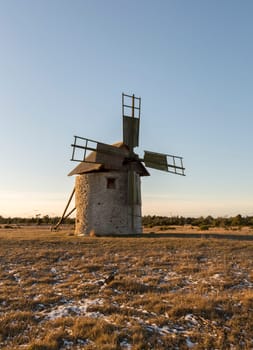 Windmill in Field with grass and snow.