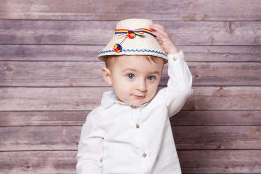 Portrait of a 1 year old baby boy wearing a Romanian traditional hat.