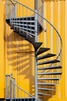 Yellow building with spiral metal staircase