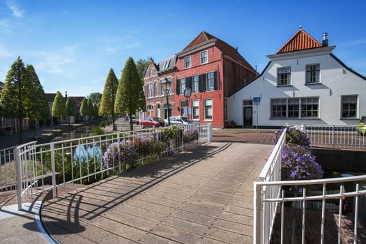 Village street and a small bridge with flowers in the Netherlands