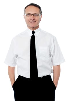 Smiling senior entrepreneur posing with hands in pockets
