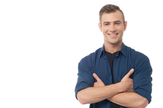 Smiling young causal guy posing with folded arms