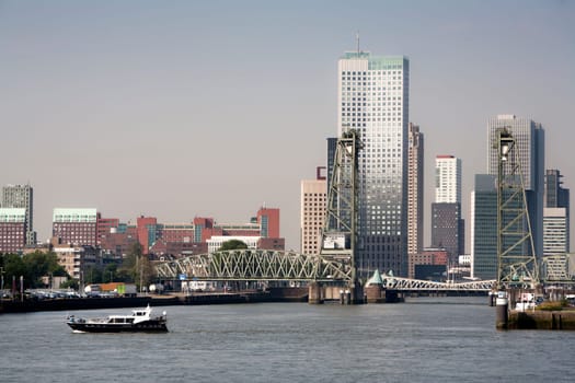 Cityscape  of the south bank of the Meuse river in Rotterdam, opposite the center of town. De Hef, the old green steel rail bridge is a monument and not in use anymore.