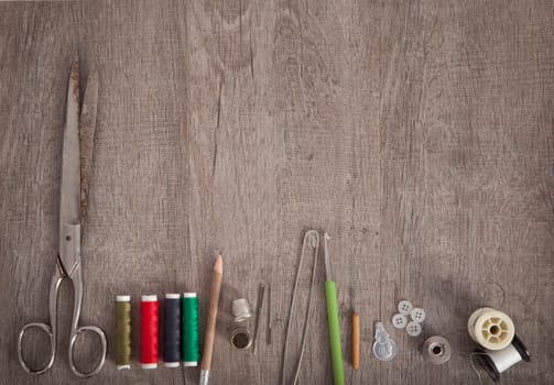 colorful fabrics and accessories for cutting lie on a wooden ground