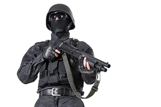 Spec ops police officer SWAT in black uniform with shotgun studio shot