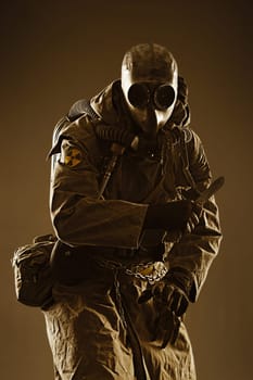 Nuclear post apocalypse. Studio shot of survivor in tatters and gas mask