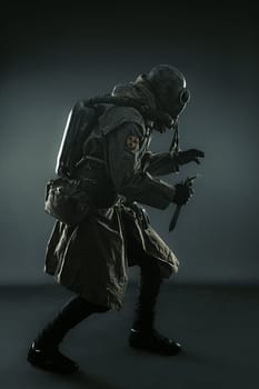Nuclear post apocalypse. Studio shot of survivor in tatters and gas mask