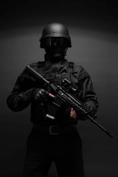 Spec ops police officer SWAT in black uniform studio