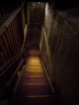 An old dangerous wooden staircase leads into the dark dungeon