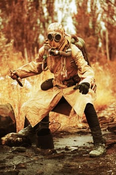 Post apocalypse. Sole survivor in tatters and gas mask on the ruins of the destroyed city