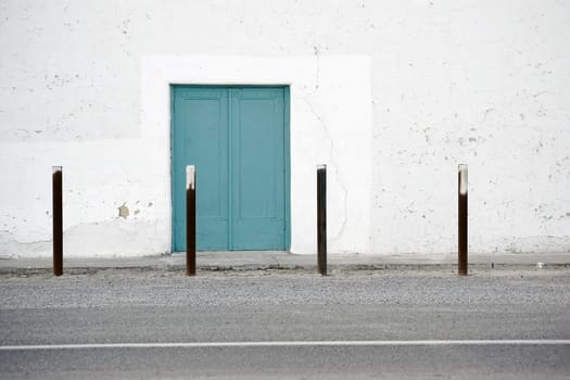 The side entrance of an old Spanish-style theatre with white plaster layers.