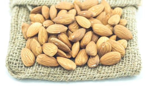 Almonds on the sack isolated on white background