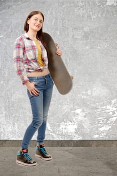 a smiling skater girl holding skateboard