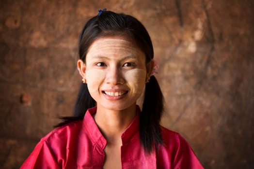Young Myanmar female with Thanaka, a yellowish-white paste made from ground bark and used as a cosmetic and for sunburn protection.