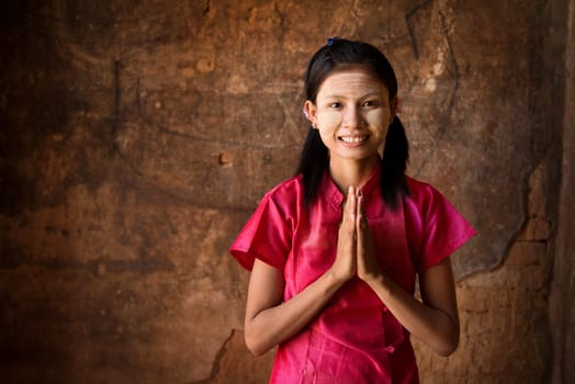 Young Myanmar woman in a traditional welcoming gesture.