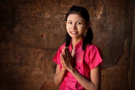 Young Myanmar girl in a traditional welcoming gesture.