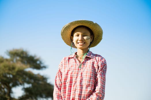 Portrait of a young Asian Myanmar farmer with thanaka powdered face who works in the field.