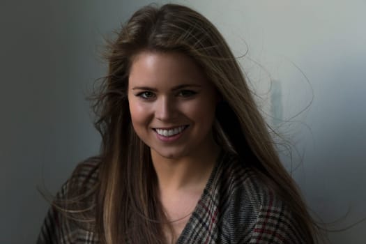 Close up portrait of an attractive young woman. She has a patterned scarf round her and is looking at the camera.