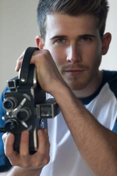 Close up portrait of an attractive young man with a video camera.