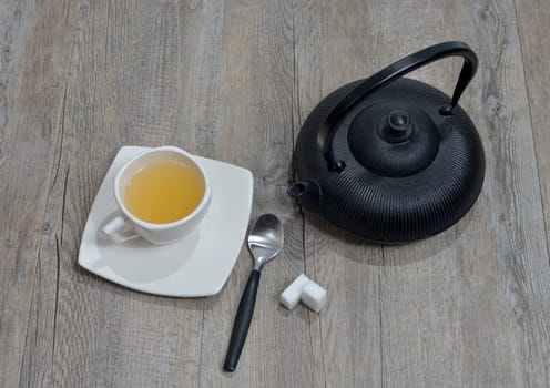 cup of tea with a teapot black.