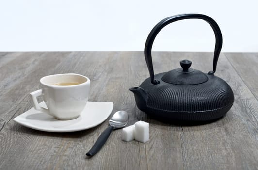 cup of tea with a teapot black.