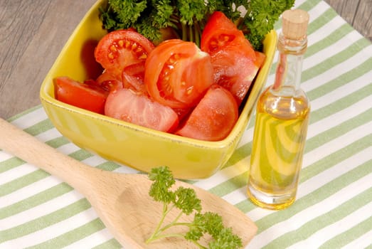 tomato salad with oil bottle on a green towel