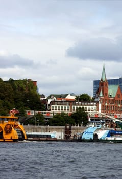 Hamburg,Germany – September 22,2014: A tram passes through the port of Hamburg with boats and sailing ships on September 22,2014 in Hamburg.