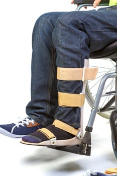 Orthopedist puts orthosis to patient in wheelchair with disabilities