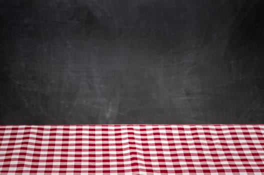 Red and white checkered tablecloth in front of black wall panel