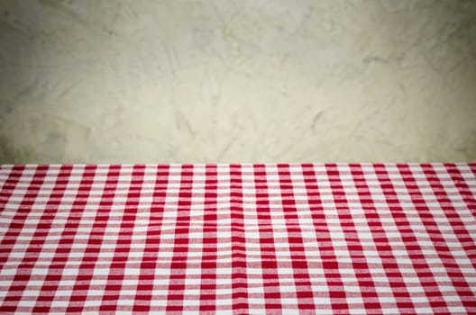 Red and white checkered tablecloth in front of rustic wall