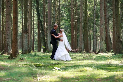 bride and groom shooting at the wedding in the forest
