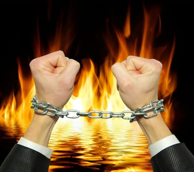 Hands in chains on a fire  background