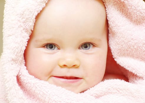 baby looking out from under blanket