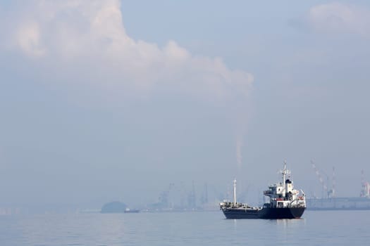 cargo freighter ship against hazy blue sky