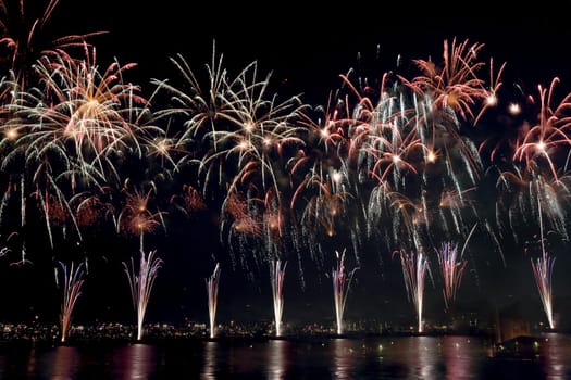 colorful fireworks reflect on sea water