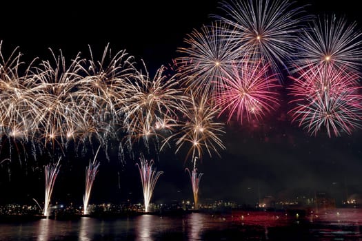 colorful fireworks reflect on sea water