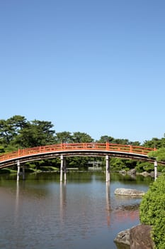 View of red wooden bridge in the Japanese park