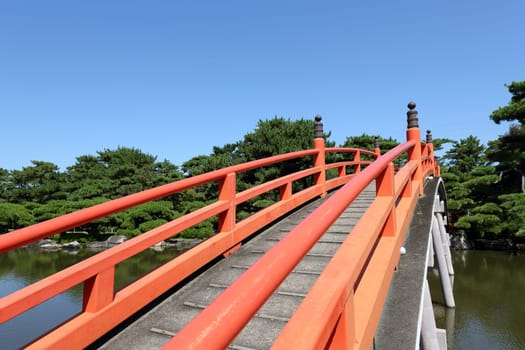 View of red wooden bridge in the Japanese park