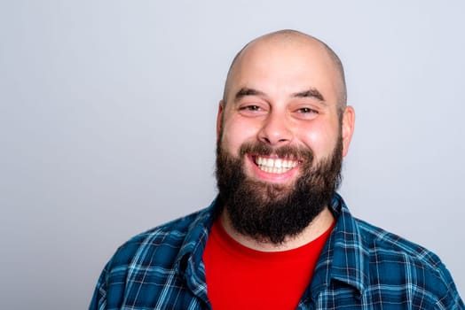 young laughing, bearded man in red and checkered shirt