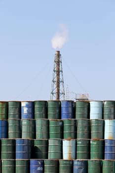 stack of oil barrels with smoke stack