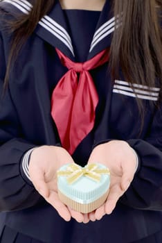 asian schoolgirl holding a gift box