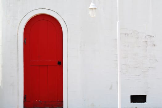 Old wooden red door with white wall